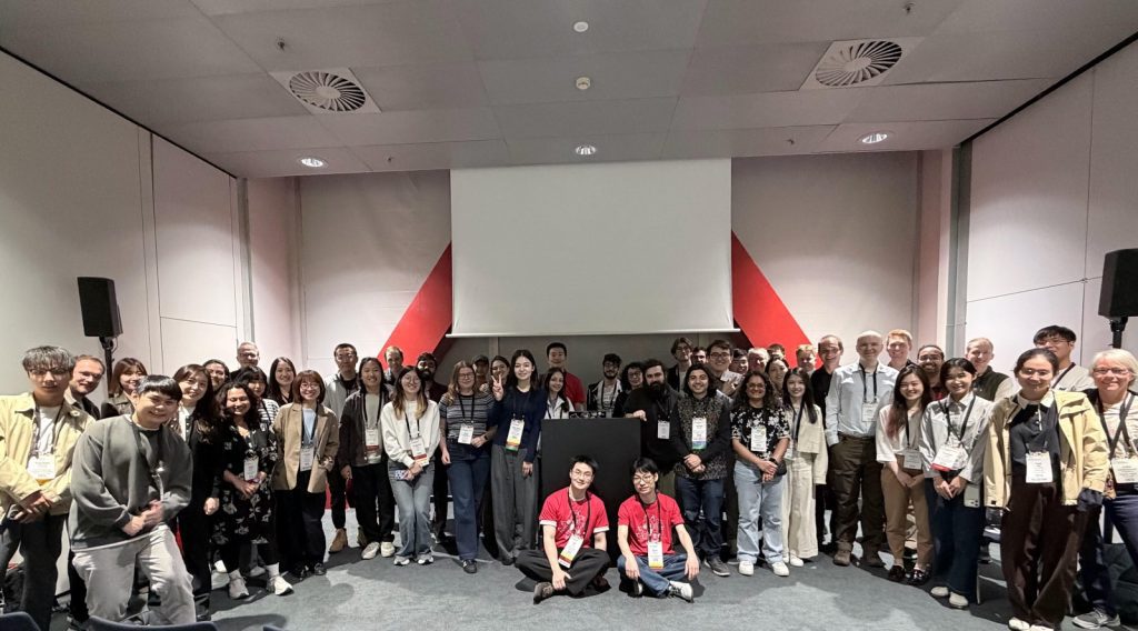 Group photo of designathon participants in a conference room at CHI 2026